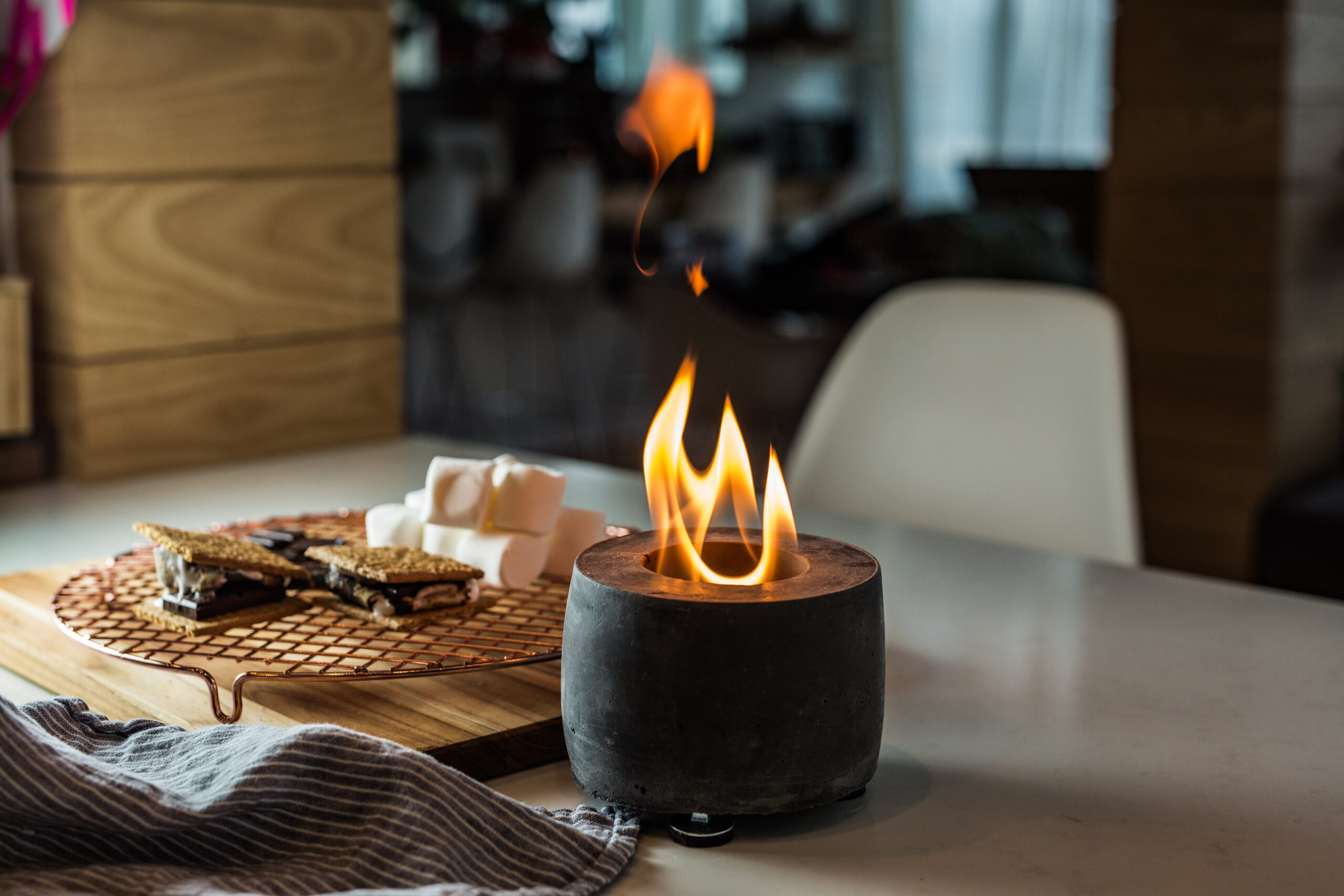 tabletop fire pit cooking smores using liquid alcohol fuel, similar to models involved in flame jetting accidents and recalled models by CPSC